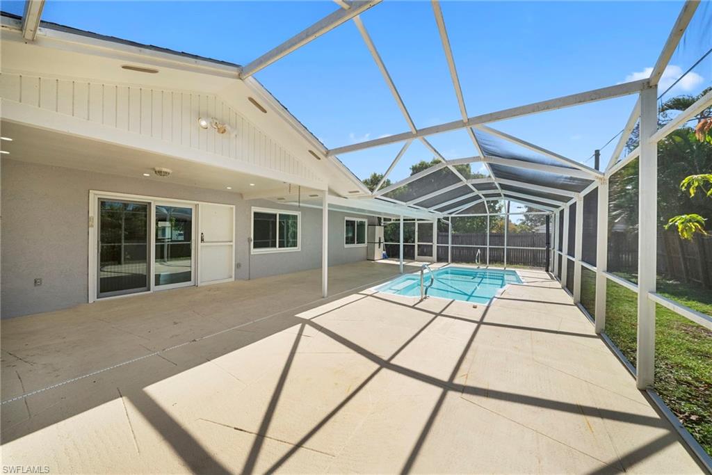 Screened pool enclosure featuring a concrete patio, rectangular swimming pool, and direct access to the interior via sliding glass doors