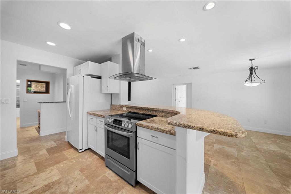 Kitchen featuring a curved granite countertop island with integrated electric range and stainless steel hood