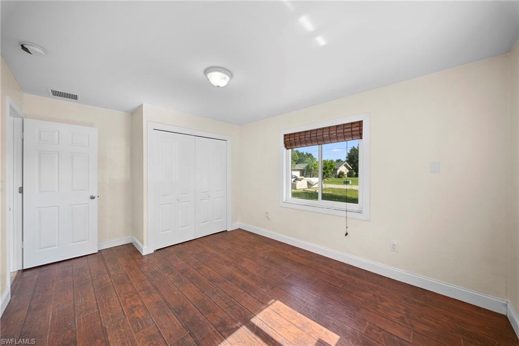 Room featuring wood-finish flooring, a double bi-fold closet, and a five-panel interior door