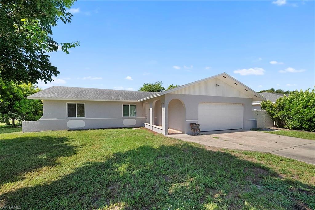 Single-story residence featuring a light gray exterior, an attached garage with a white door, and a concrete driveway