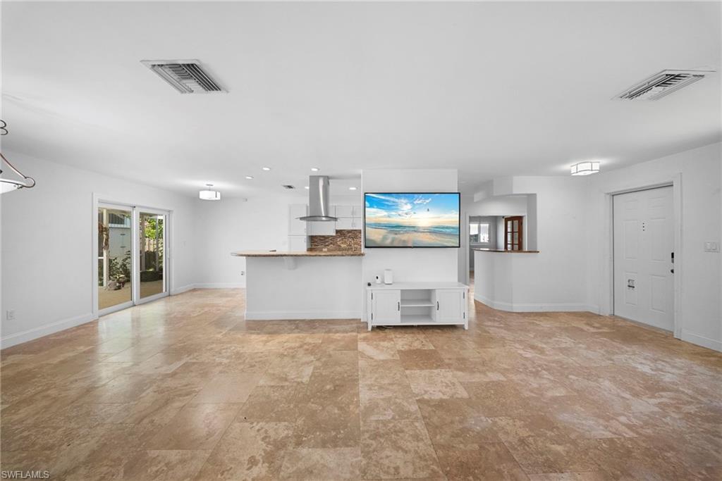 Expansive open-concept interior featuring light-toned tile flooring throughout