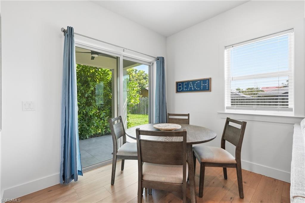 Open-concept dining area featuring light wood-finish flooring and white walls