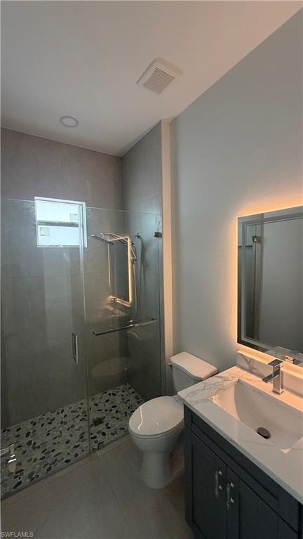 Bathroom featuring a glass-enclosed shower with pebble flooring and gray tile surround