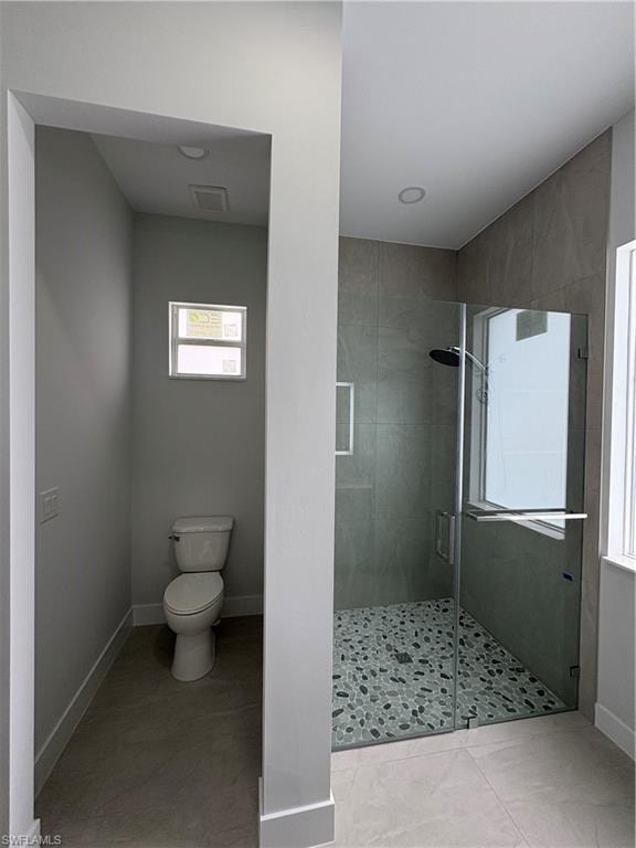Contemporary bathroom featuring a spacious glass-enclosed shower with pebble-finish flooring and full-height tiled walls
