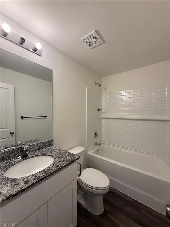 Bathroom featuring a white vanity with a granite countertop, undermount sink, and chrome faucet