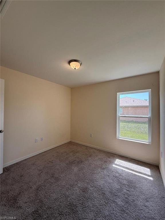 Spacious room with neutral wall tones and plush, textured carpeting