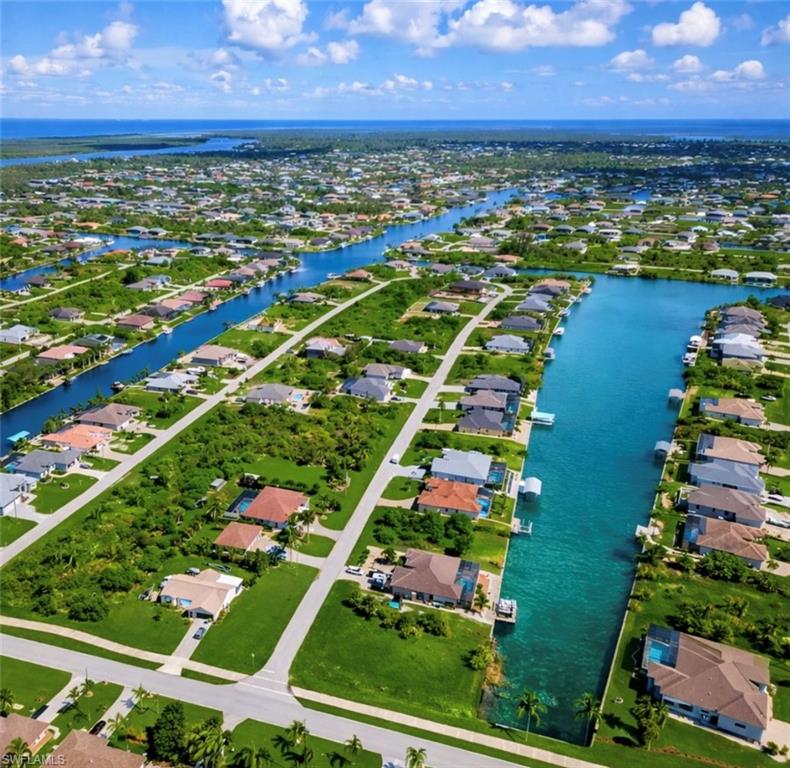 Coastal canal community featuring numerous single-story properties with lush landscaping and private docks
