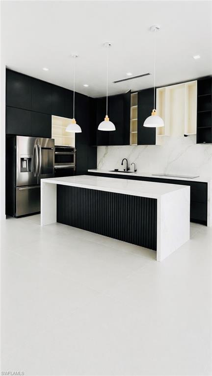 Kitchen featuring a waterfall-edge island with a fluted panel base, stainless steel appliances, and a marble-patterned backsplash (Rendered photo)