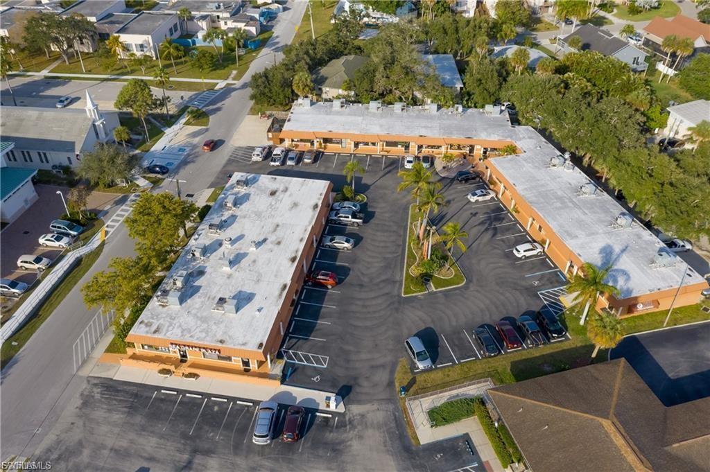 Multi-building commercial property featuring ample paved parking, established landscaping with palm trees, and direct street frontage