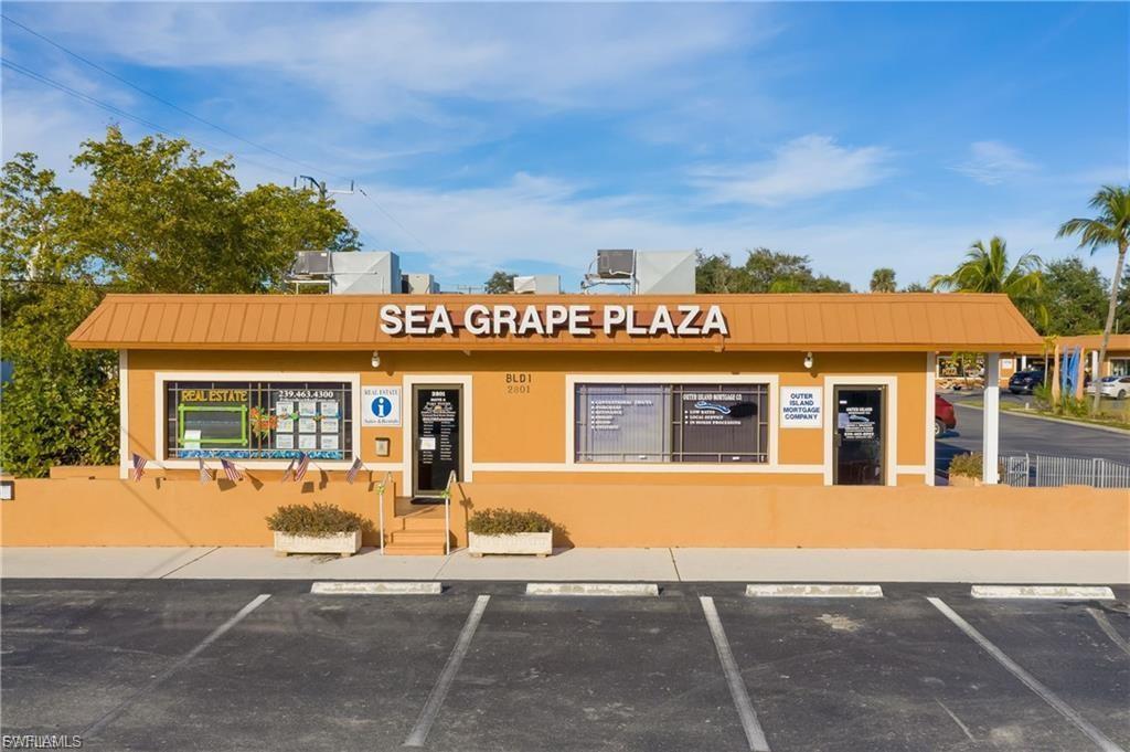 Commercial building featuring a terracotta-toned exterior, a coordinating brown roof, and multiple large storefront windows