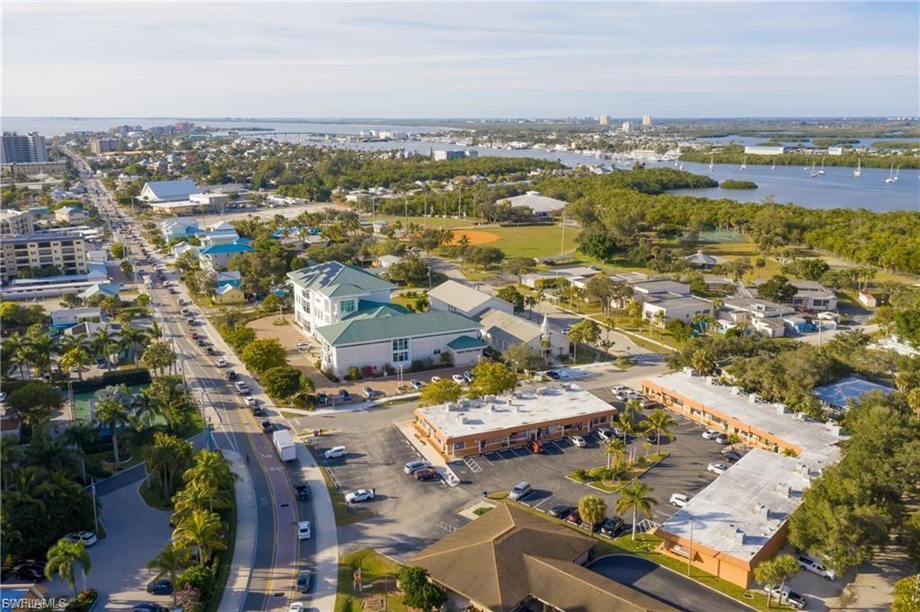 Aerial perspective showcasing a vibrant coastal community with a visible waterway featuring numerous boats