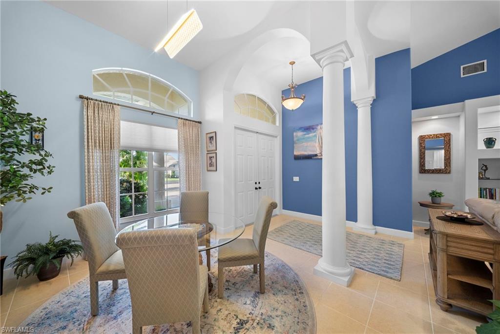 Vaulted ceilings with architectural columns, arched transom windows, and built-in shelving
