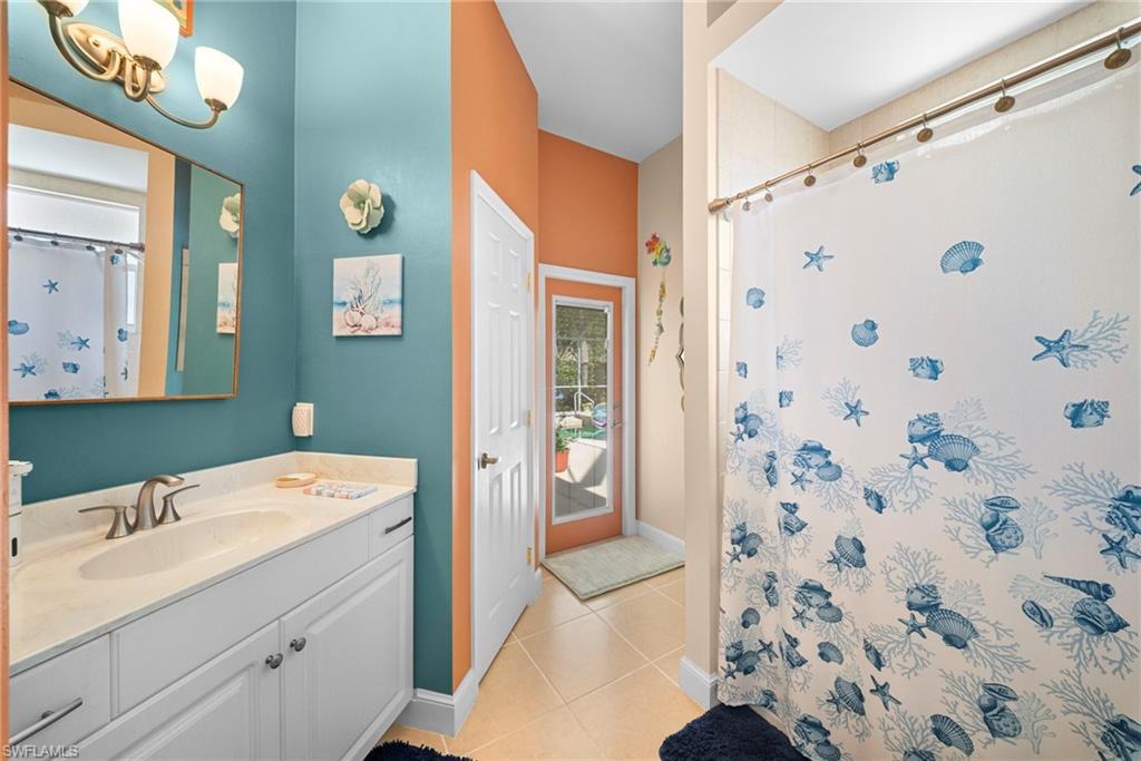 White vanity with brushed nickel hardware, single basin sink, and an attached wall mirror