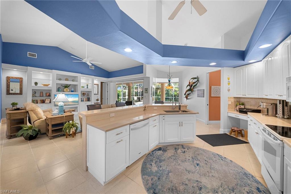 Kitchen featuring white cabinetry, light-toned countertops, tile flooring, and integrated appliances