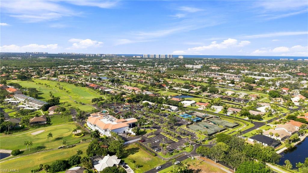 Expansive golf course community featuring numerous residential properties and recreational facilities including a large clubhouse, multiple tennis courts, and a waterway