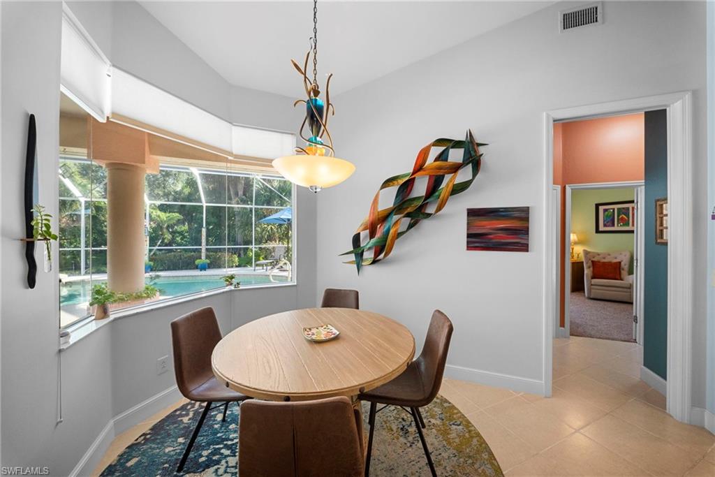 Bay window with pool and garden backdrop, complemented by recessed lighting and a decorative hanging fixture