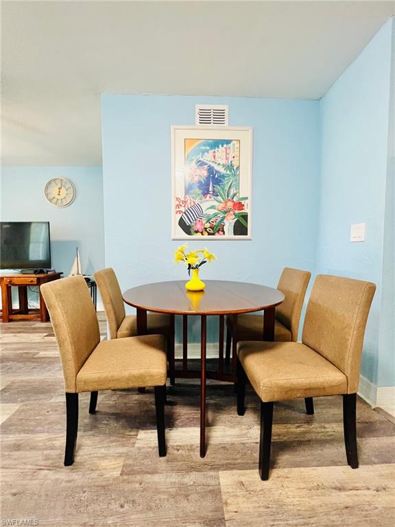 Dining area featuring light blue walls and wood-finish flooring