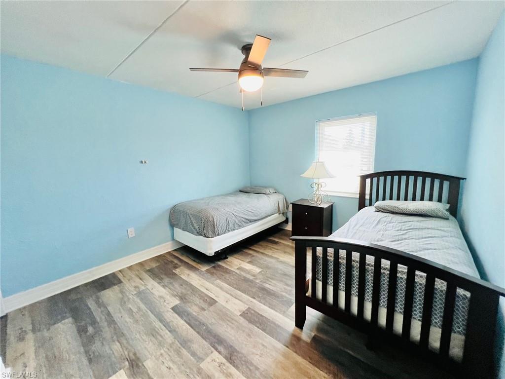 Room featuring wood-finish flooring, light blue walls, and a window with natural light