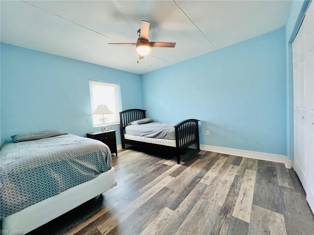 Spacious room featuring wood-finish flooring, a contemporary ceiling fan, and abundant natural light from a single window