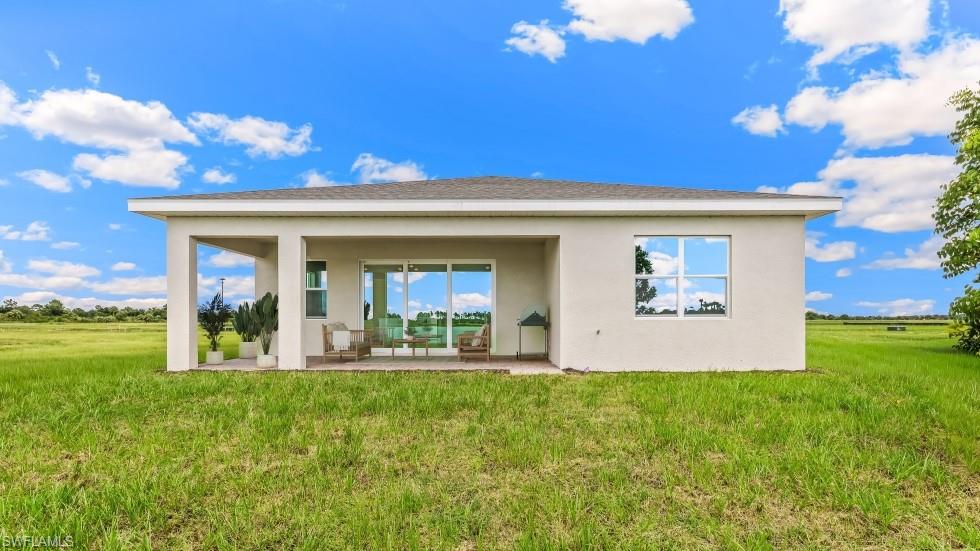 Rear exterior featuring a covered patio, sliding glass doors, and a large picture window