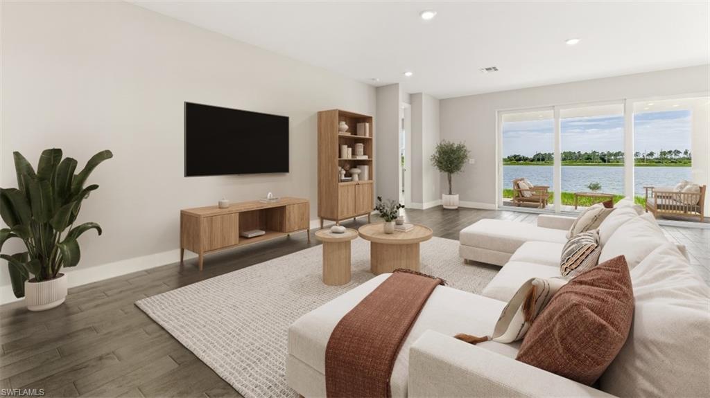 Recessed lighting, wood-finish flooring, and large sliding glass doors opening to a water feature