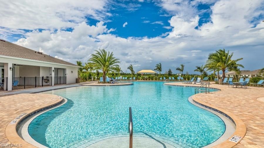 Expansive resort-style pool with integrated steps, surrounded by a paver deck