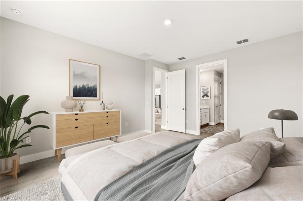 Recessed lighting, light wood-finish flooring, white walls, and a built-in wood-front dresser