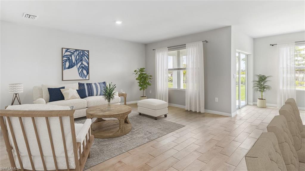 Open-concept living area featuring light-toned tile flooring throughout