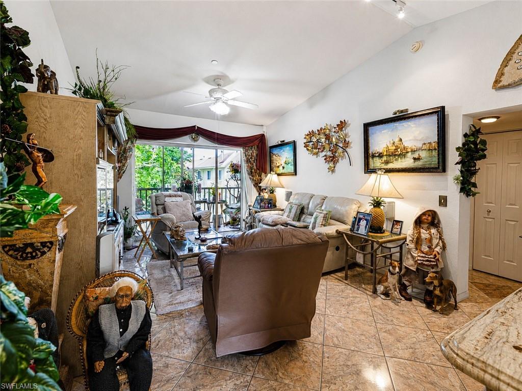 Spacious living area featuring vaulted ceilings, track lighting, and tiled flooring