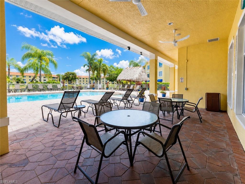 Covered patio with a textured ceiling, a stamped concrete and brick paver floor, and multiple ceiling fans