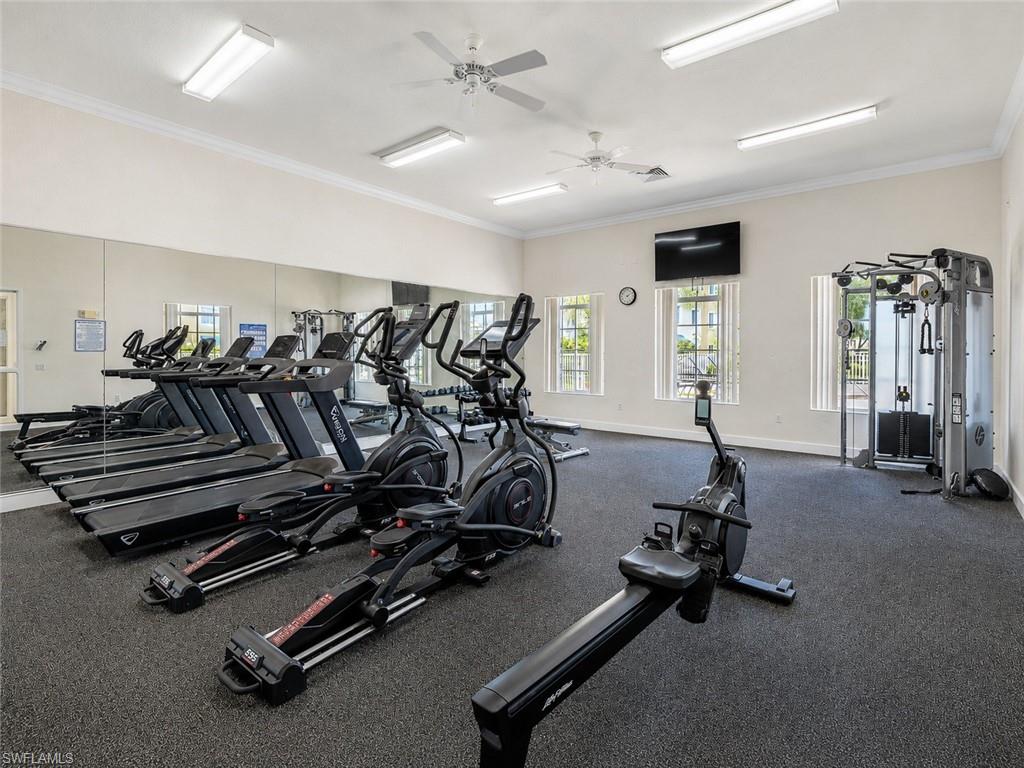 Fitness center featuring a mirrored wall, multiple cardio machines, a rowing machine, and a multi-station weight machine