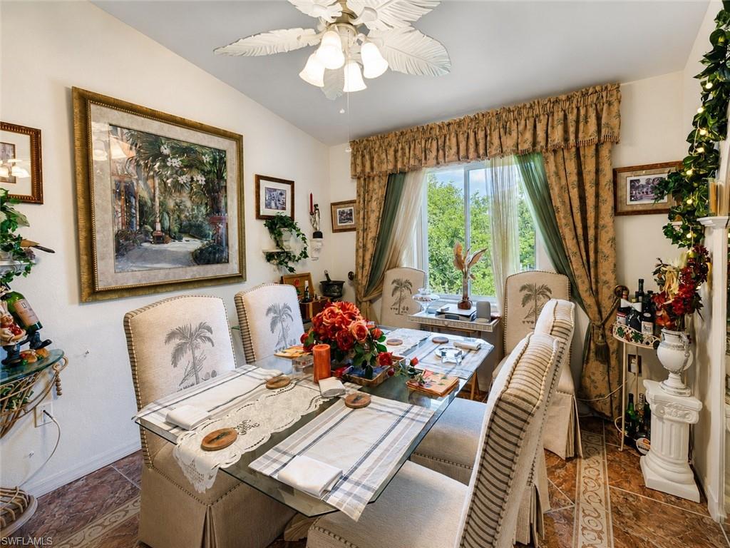 Dining area featuring patterned tile flooring and a ceiling fan with leaf-shaped blades