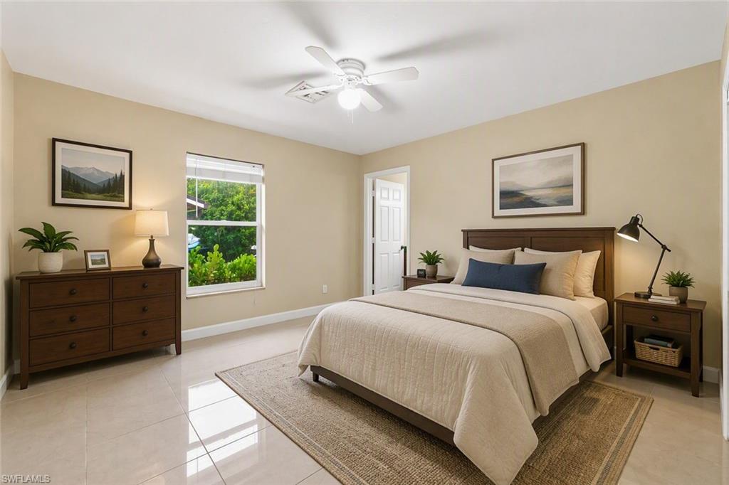 Bright room featuring tile flooring, a window with exterior tree foliage, and a ceiling fan with integrated lighting