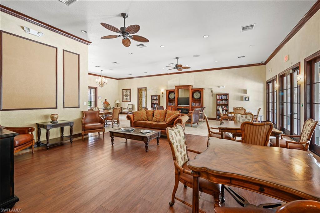 Spacious common area featuring wood-finish flooring, crown molding, multiple ceiling fans, and recessed lighting
