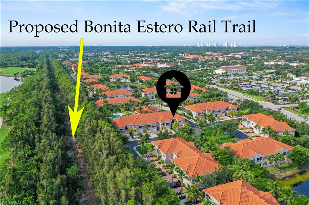 Aerial perspective showcasing a residential community with red-tiled roofs, mature landscaping, and water features