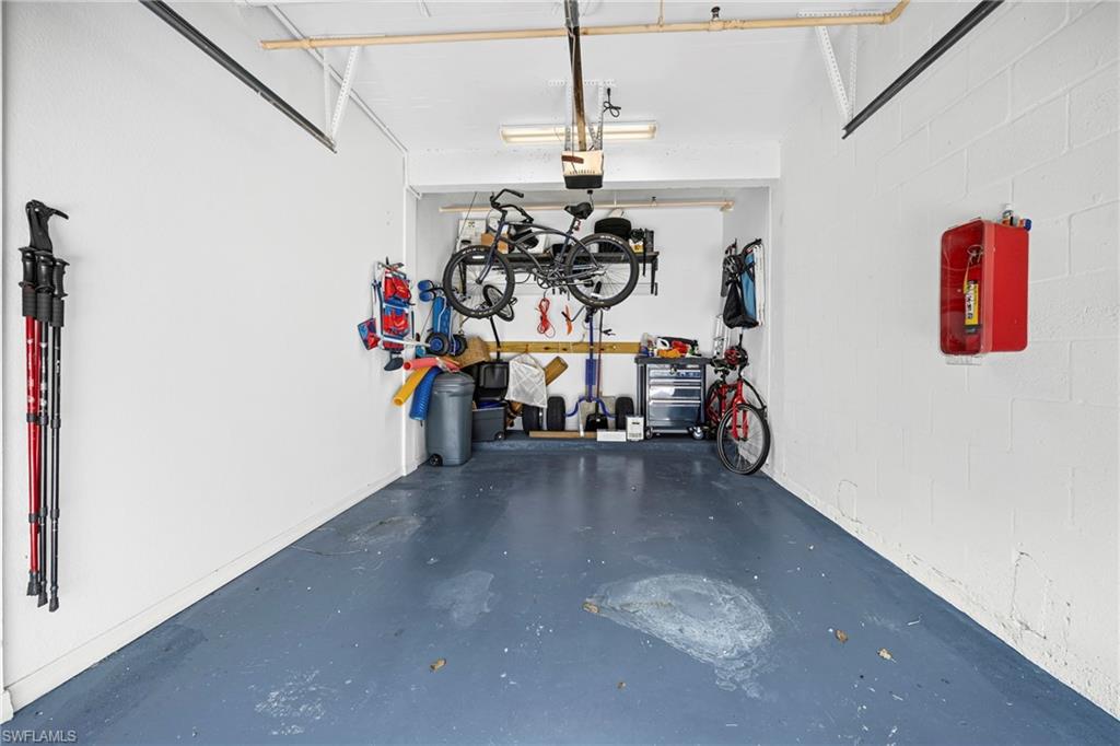 Spacious garage featuring white-painted cinder block walls and a blue-painted concrete floor