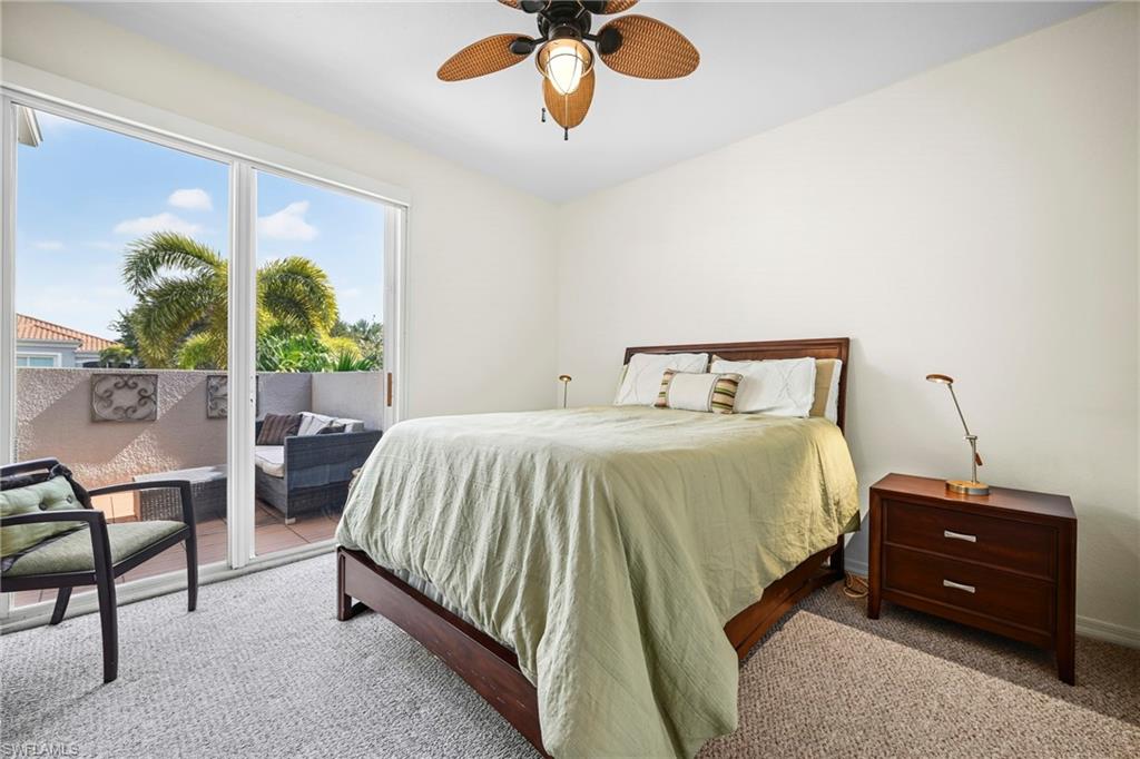 Bedroom featuring neutral-toned carpeting and a ceiling fan with woven blades