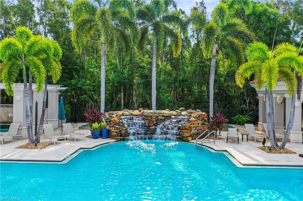 Resort-style pool with a stone waterfall feature and integrated steps