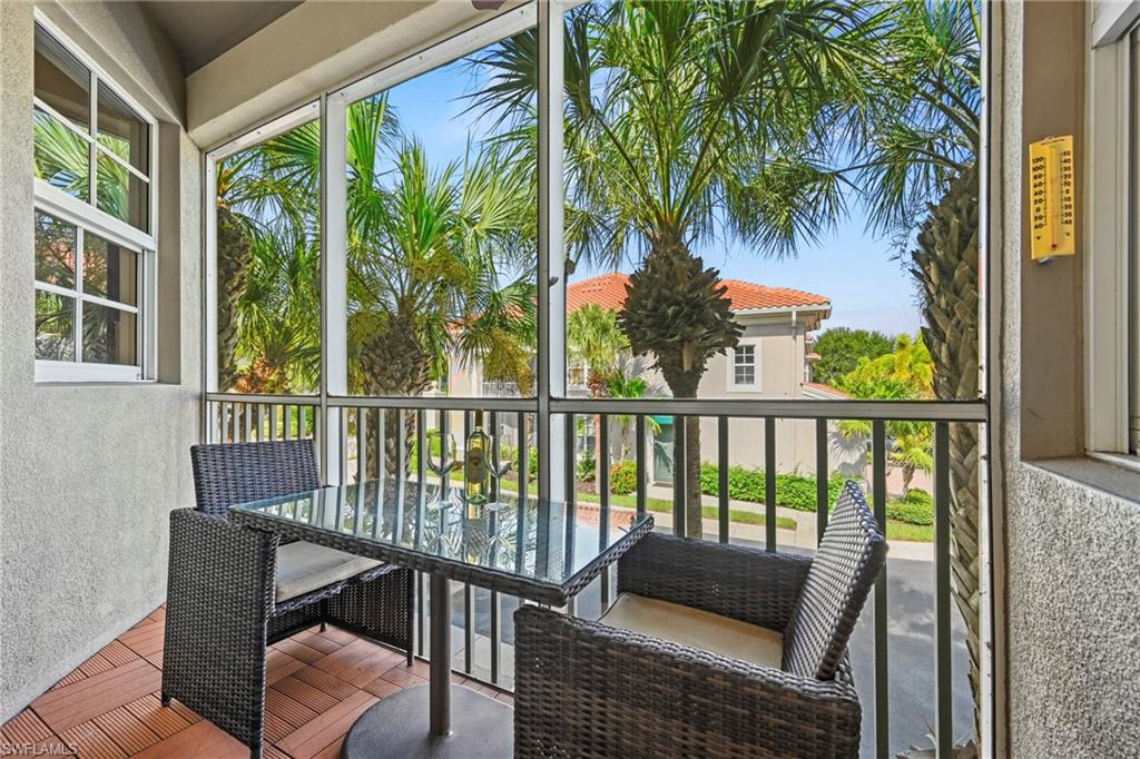 Screened balcony featuring wood-finish floor tiles and a window with grid patterns