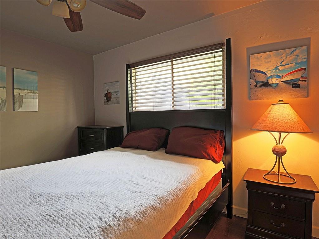 Bedroom featuring a dark wood bed frame, coordinating nightstands, and a ceiling fan with integrated lighting