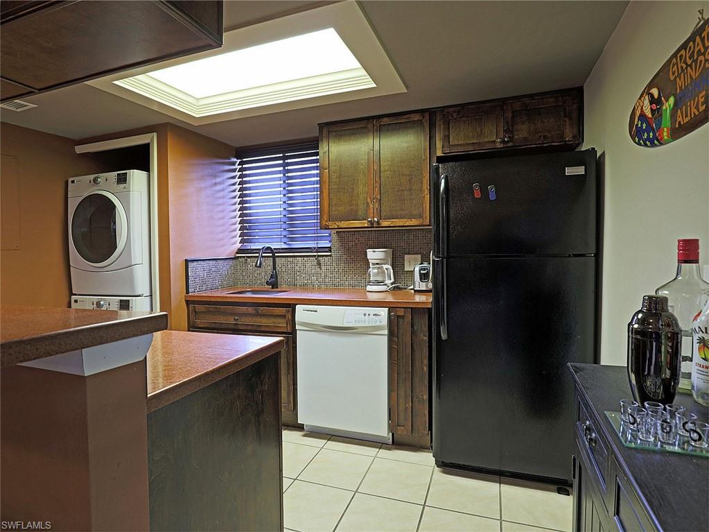 Kitchenette featuring wood-finish cabinetry, tile flooring, and integrated appliances