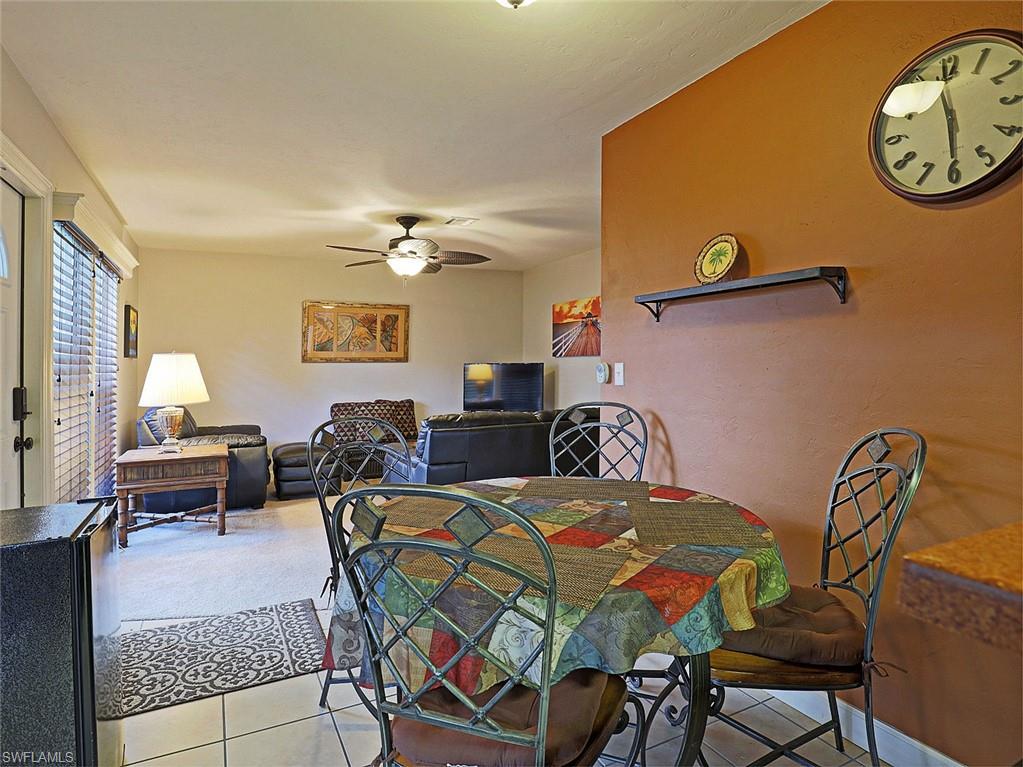 Spacious open-concept living area featuring a ceiling fan, neutral wall tones, and bright natural light from the exterior door with privacy blinds