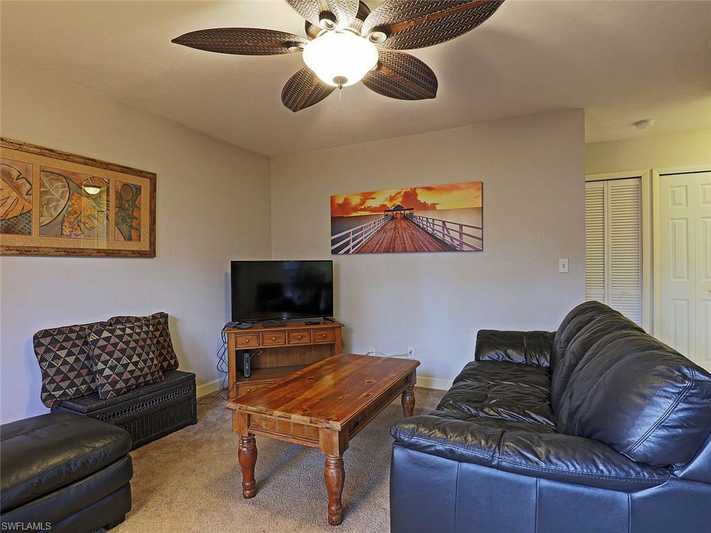 Living area featuring wall-to-wall carpeting and a ceiling fan with integrated lighting