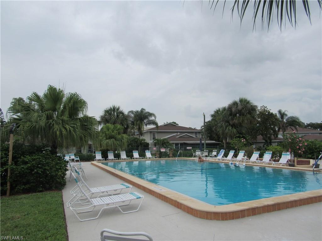 Community swimming pool featuring a tiled edge and surrounding concrete deck