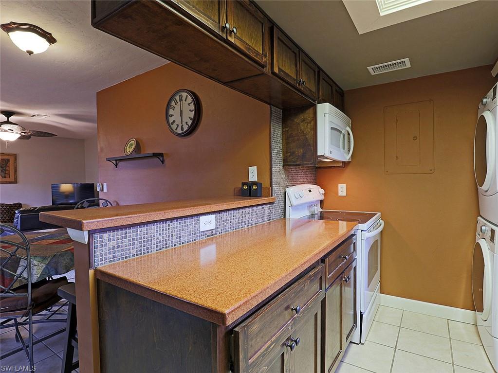 Kitchen area featuring a breakfast bar with speckled countertops and a mosaic tile backsplash