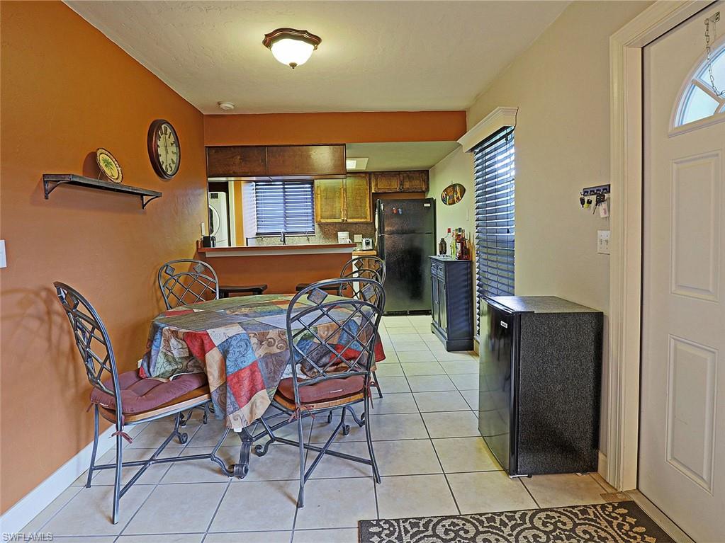 Dining area featuring tile flooring, a built-in wall shelf, and direct access to the kitchen