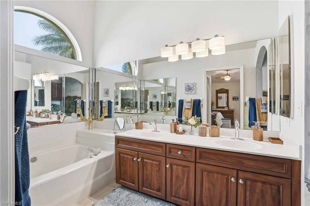 Bathroom featuring a double vanity with wood cabinetry, white countertops, and dual oval sinks