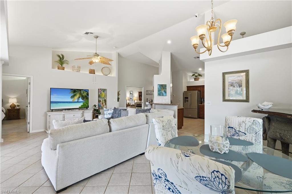 Open-concept living space with vaulted ceilings, recessed lighting, and tile flooring