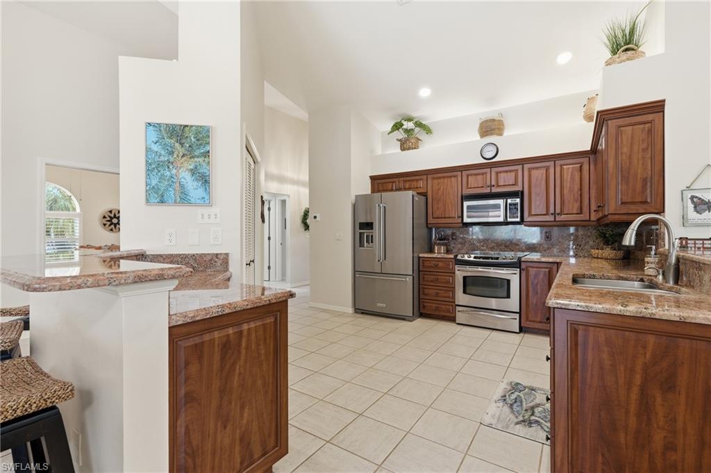 Kitchen featuring wood cabinetry with ample storage, stainless steel appliances, and a double-basin sink