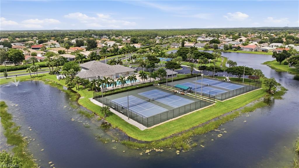 Aerial view showcasing the community clubhouse, multiple tennis courts, and surrounding waterways